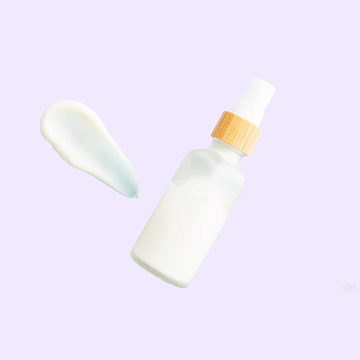 Frosted glass bottle of lotion cream on gray background.